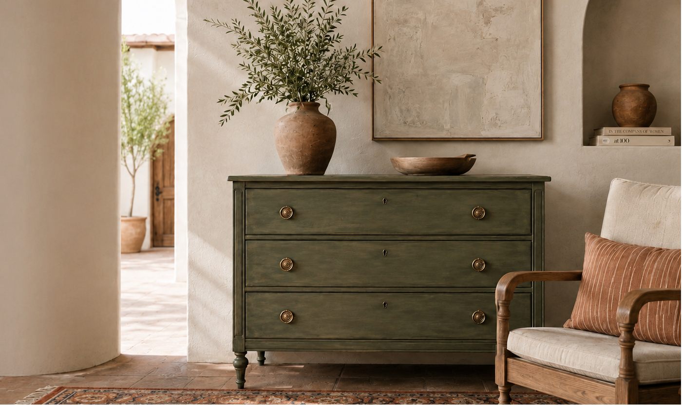 Green dresser in a room with a chair, rug, and decorative items.