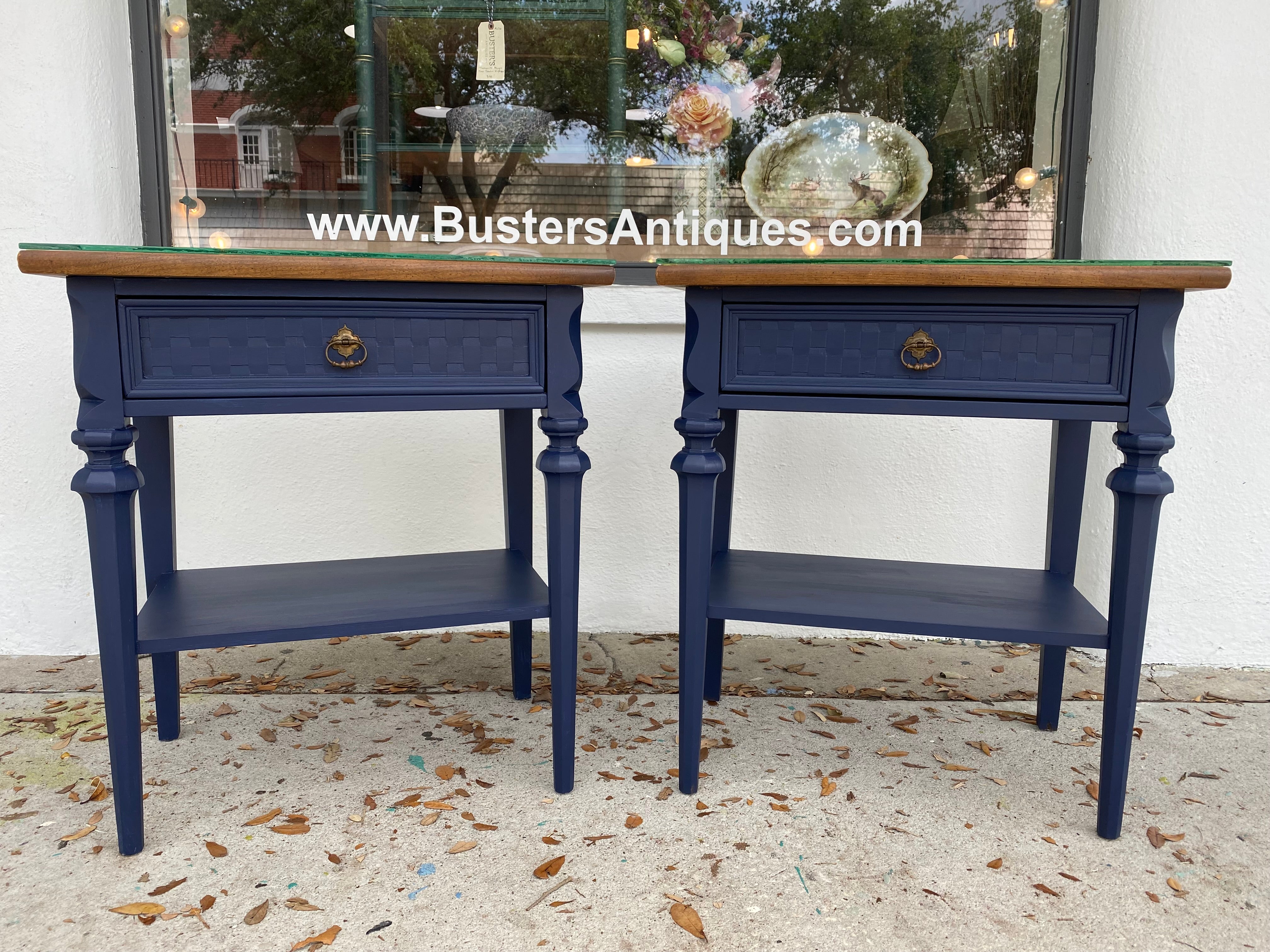 A pair of blue nightstands with a wood top with glass protection.